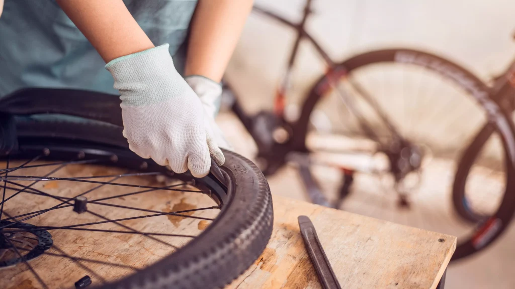 un professionnel de réparation de velo entrain de réparer une crevaison
